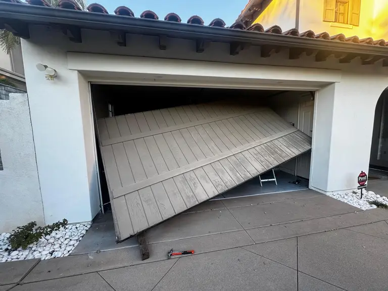 Residential garage door collapsed off its tracks at a Spanish-style Los Angeles home, emergency off-track repair