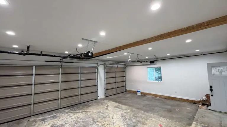 Interior view of two-car garage with two freshly installed LiftMaster belt drive openers with LED lighting system in Los Angeles