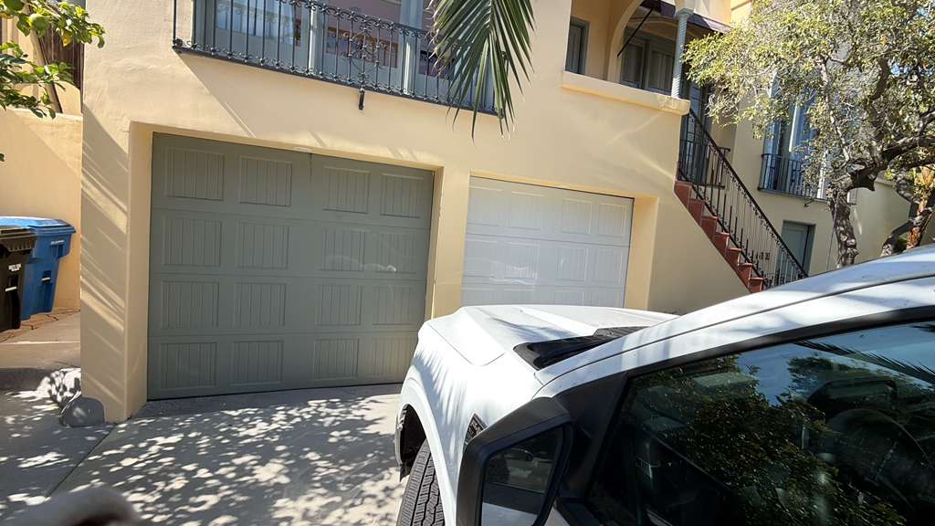 Roll-up commercial garage door with damaged panels being repaired in North Hollywood commercial property